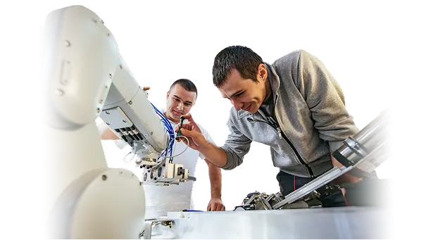 Two engineers working together to adjust an industrial robotic system